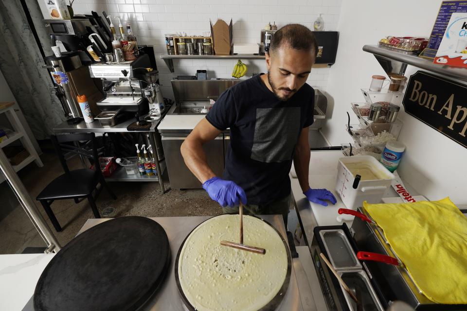 New U.S. citizen Jad "Jay" Jawad, owner of the Crepe House Cafe, who came to the U.S. as a refugee from war-torn Iraq, makes a crepe in his cafe on Friday, Sept. 4, 2020 in Phoenix. He said that during presidential elections in his native country, Saddam Hussein was the only candidate on the ballot and the only real option was "yes," because a "no" vote could get you jailed or worse. Now, he said he is looking to voting freely in his first U.S. presidential election this fall. (AP Photo/Ross D. Franklin)