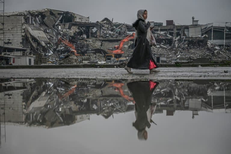 Une femme passe au milieu des décombres du séisme qui a fait plus de 53.500 morts en février 2023, à Antakya le 12 janvier 2024 (Ozan KOSE)
