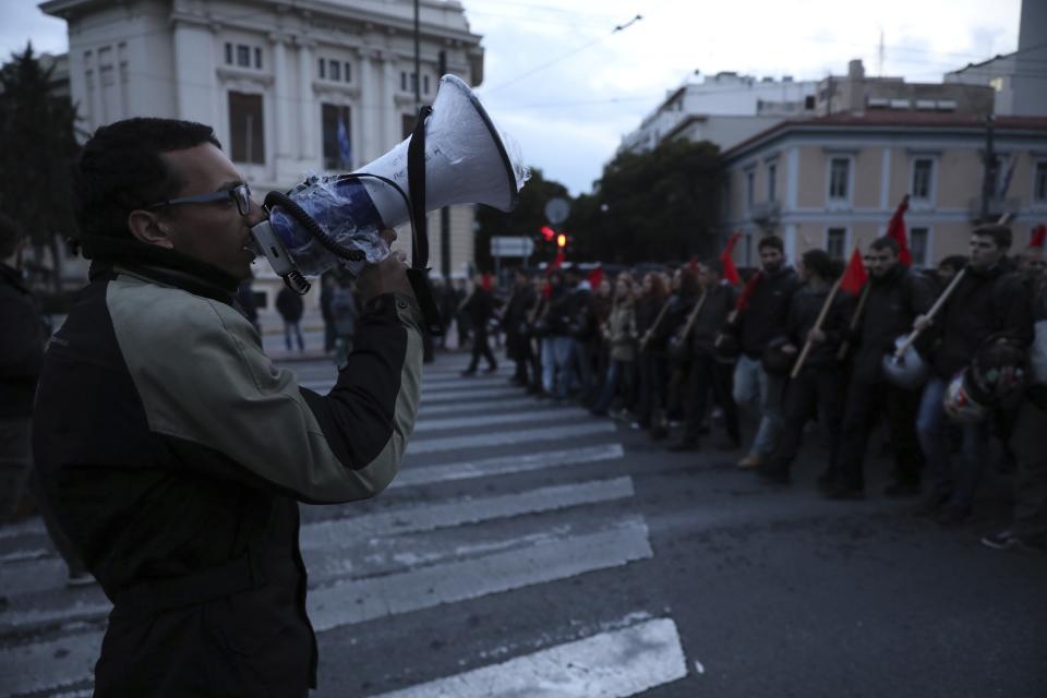 A protester uses a loudspeaker to chat slogans during a rally in Athens, Saturday, Nov. 17, 2018. Several thousands people march to the U.S. Embassy in Athens under tight police security to commemorate a 1973 student uprising that was crushed by Greece's military junta, that ruled the country from 1967-74. (AP Photo/Yorgos Karahalis)