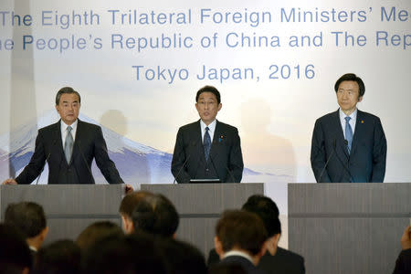 Japanese Foreign Minister Fumio Kishida (C) reads a statement after a trilateral meeting with Chinese Foreign Minister Wang Yi (L) and South Korean Foreign Minister Yun Byung-Se in Tokyo, Japan, August 24, 2016. REUTERS/Katsumi Kasahara/ Pool