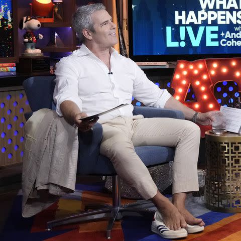 <p>Charles Sykes/Bravo via Getty Images</p> Andy Cohen removed his shoes to cool off on a recent episode of 'Watch What Happens Live.'