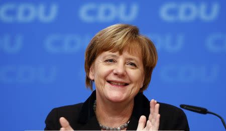 German Chancellor and leader of the Christian Democratic Union (CDU) Angela Merkel applauds after the overwhelming vote on a declaration about refugees during the CDU party congress in Karlsruhe, Germany December 14, 2015. REUTERS/Kai Pfaffenbach