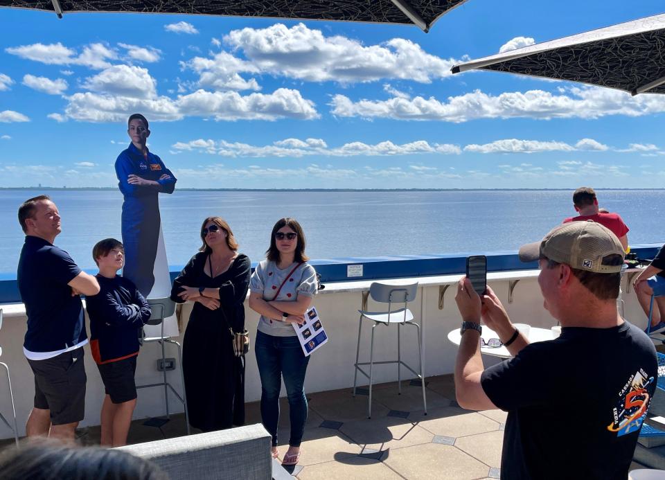 Supporters pose alongside a cardboard cutout of NASA-SpaceX Crew-5 mission commander Nicole Mann at The Space Bar in Titusville.