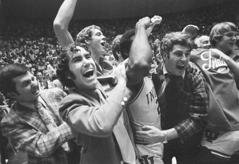 FILE - Indiana coach Bob Knight, right, celebrates with the team and fans after the team's win over Marquette in the NCAA men's college basketball tournament Mideast regionals in Baton Rouge, La., in March 1976. When it was introduced 75 years ago, the purpose of the AP Top 25 men's college basketball poll was to foster discussion and debate. That has not changed. (AP Photo, File)