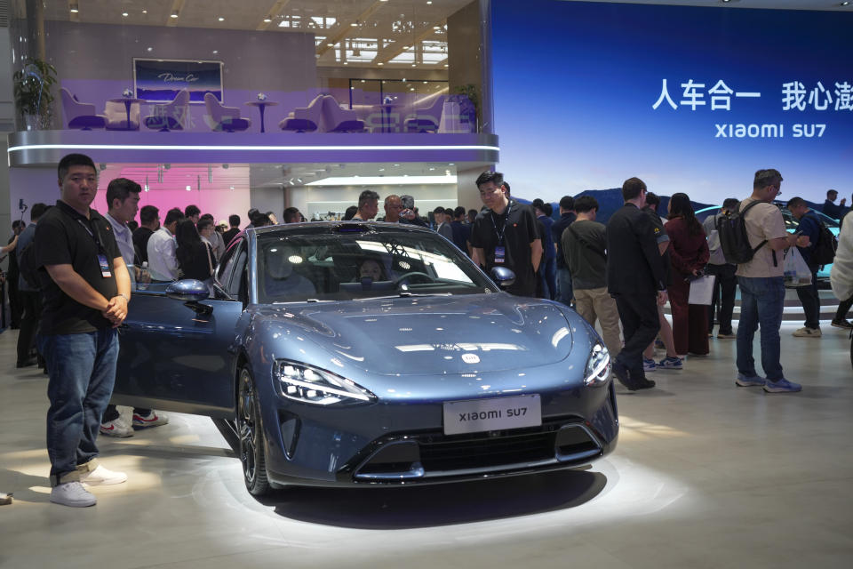 People look at a Xiaomi SU7 car during China Auto Show in Beijing, China, Friday, April 26, 2024. China's vision of the future of the automobile electrified and digitally connected is on display at the ongoing Beijing auto show. (AP Photo/Tatan Syuflana)