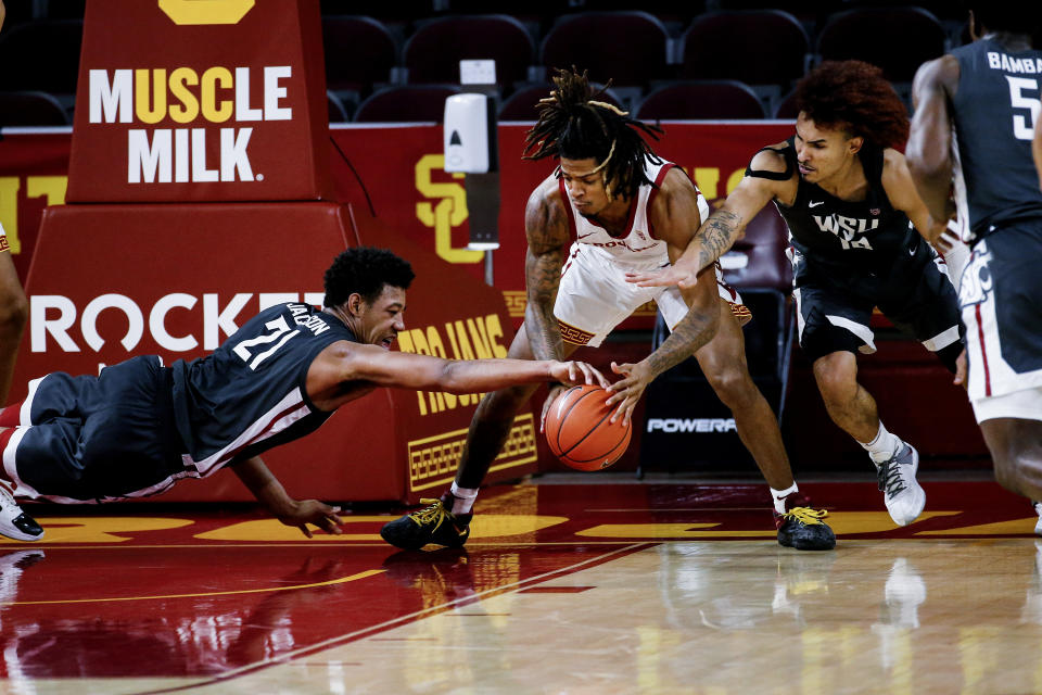 Southern California guard Isaiah White, center, and Washington State center Dishon Jackson, left, and guard Isaac Bonton reach for the ball during the second half of an NCAA college basketball game Saturday, Jan. 16, 2021, in Los Angeles. (AP Photo/Ringo H.W. Chiu)