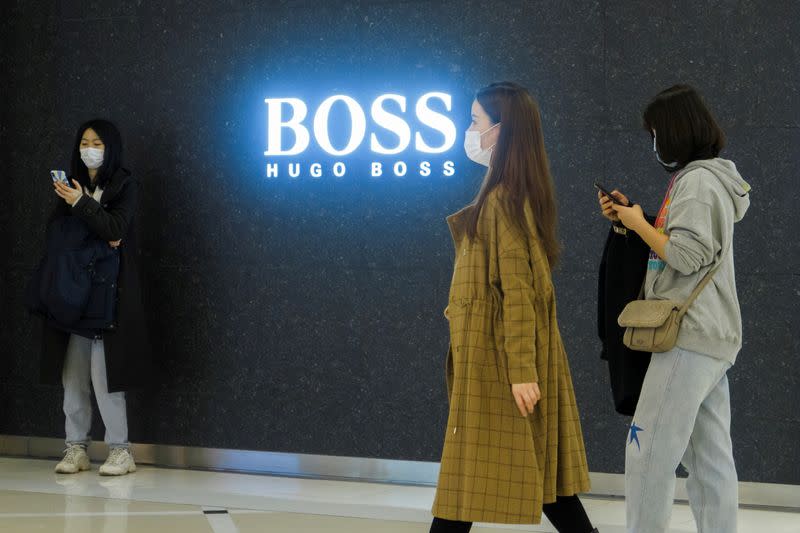 FILE PHOTO: People walk past a store of German fashion house Hugo Boss in Beijing