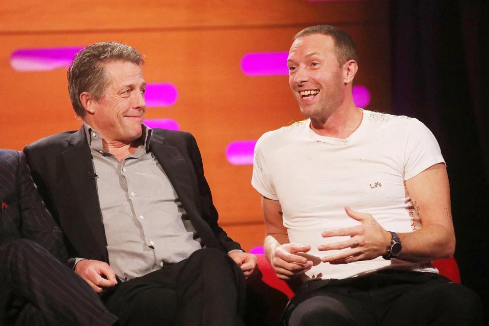 Chris Martin talks animatedly while Hugh Grant listens during a taping of <i>The</i> <i>Graham Norton Show</i> in London on Thursday.