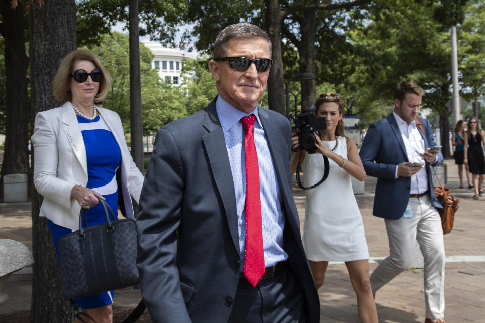 FILE - In this June 24, 2019, file photo, former national security adviser Michael Flynn, leaves the federal courthouse in Washington. with his lawyer Sidney Powell, left. Federal prosecutors say it’s too soon to take a position on sentencing for Flynn because he could still be a defense witness in the upcoming trial of a one-time business partner.(AP Photo/Manuel Balce Ceneta, File)