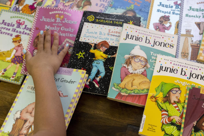 Ke'Arrah Jessie, 9, shows her favorite Junie B. Jones books in Niagara Falls, N.Y., on Monday, April 3, 2023. Ashley Martin has passed her love of the Junie B. Jones series of books to her daughter, Ke’Arrah, and the pair read them together at bedtime. (AP Photo/Lauren Petracca)