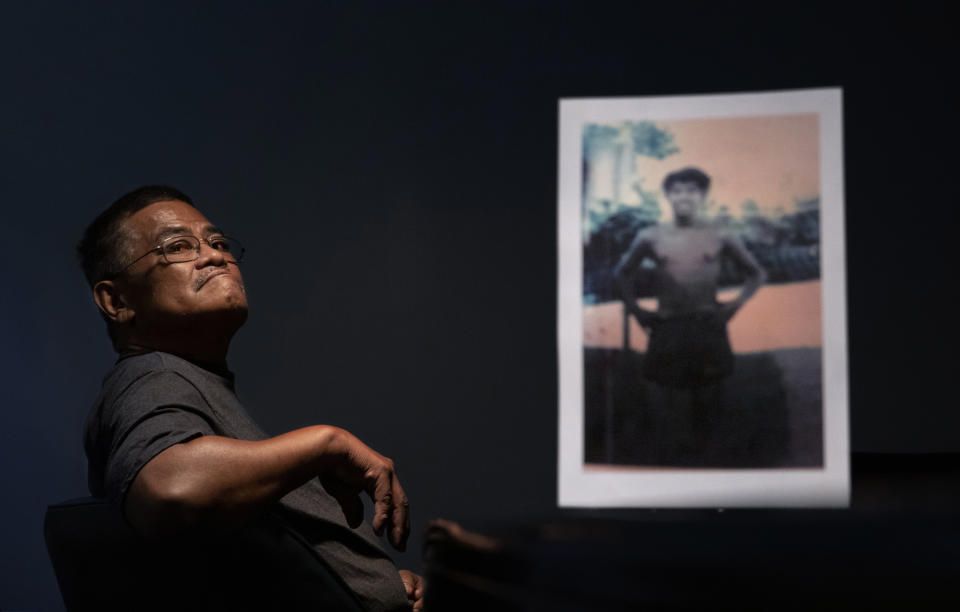 Anthony Vegafria, 59, sits behind a photo of himself when he was 13 years old, the age when he says in a lawsuit he was sexually abused by Louis Brouillard, a Catholic priest and scoutmaster for the Boy Scouts of America, in Hagatna, Guam, Monday, May 13, 2019. "Sometimes I don't really want to think about it," said Vegafria of the abuse. Vegafria says in a lawsuit he was abused between the ages of 12 and 15 by Brouillard on parish grounds while he served as altar boy and also on outings with the Boy Scouts. Brouillard has acknowledged abuse allegations and is now dead. (AP Photo/David Goldman)