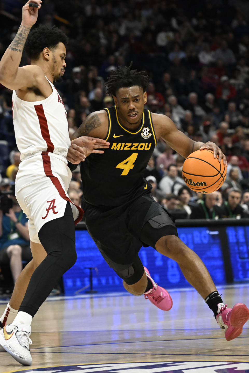 Missouri guard DeAndre Gholston (4) drives on Alabama guard Dominick Welch during the first half of an NCAA college basketball game in the semifinals of the Southeastern Conference Tournament, Saturday, March 11, 2023, in Nashville, Tenn. (AP Photo/John Amis)