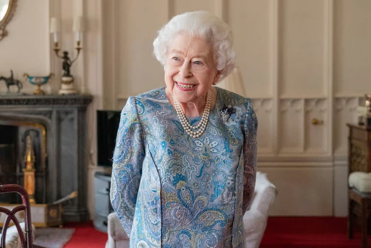 Queen Elizabeth smiles while receiving the President of Switzerland Ignazio Cassis and his wife Paola Cassis during an audience at Windsor Castle in April 2022.  (AP)