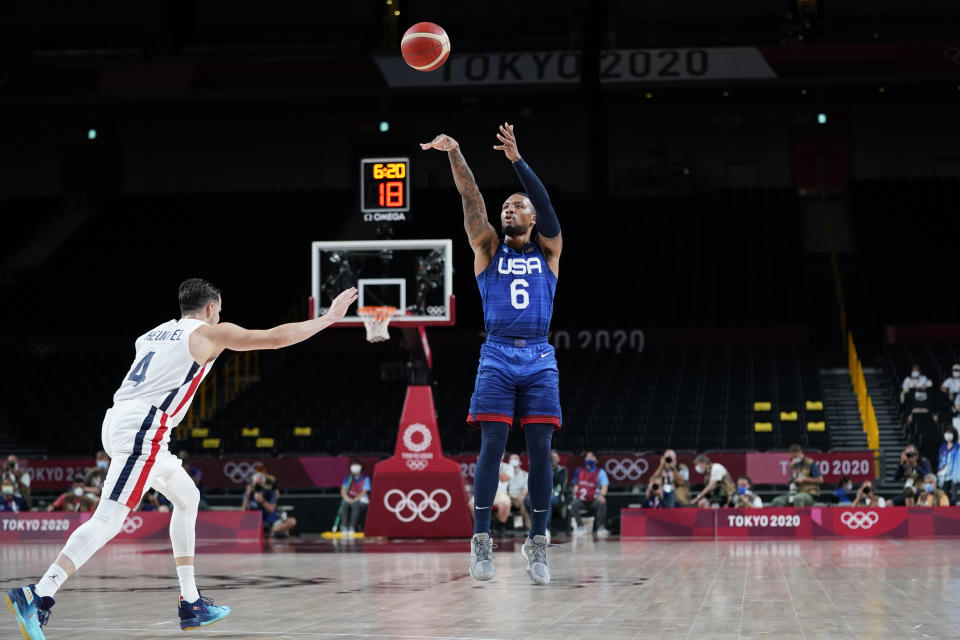 United States' Damian Lillard (6) shoots a 3-point basket over France's Thomas Heurtel, left, during a men's basketball preliminary round game at the 2020 Summer Olympics, Sunday, July 25, 2021, in Saitama, Japan. (AP Photo/Charlie Neibergall)