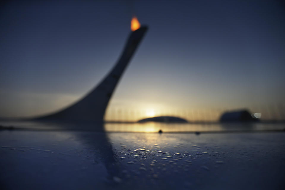 Drops of water sit along the edge of the pool at the Olympic cauldron as the sun sets in Sochi, Russia, at the 2014 Winter Olympics, Feb. 21, 2014.