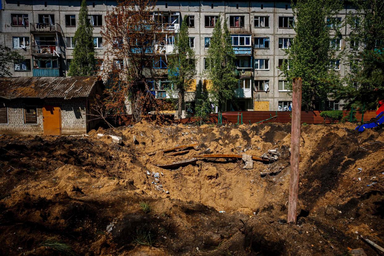 A photograph shows a damaged residenial buildin and crater, after missile strikes in Chasiv Yar near the frontline city of Bakhmut, Donetsk region (AFP via Getty Images)