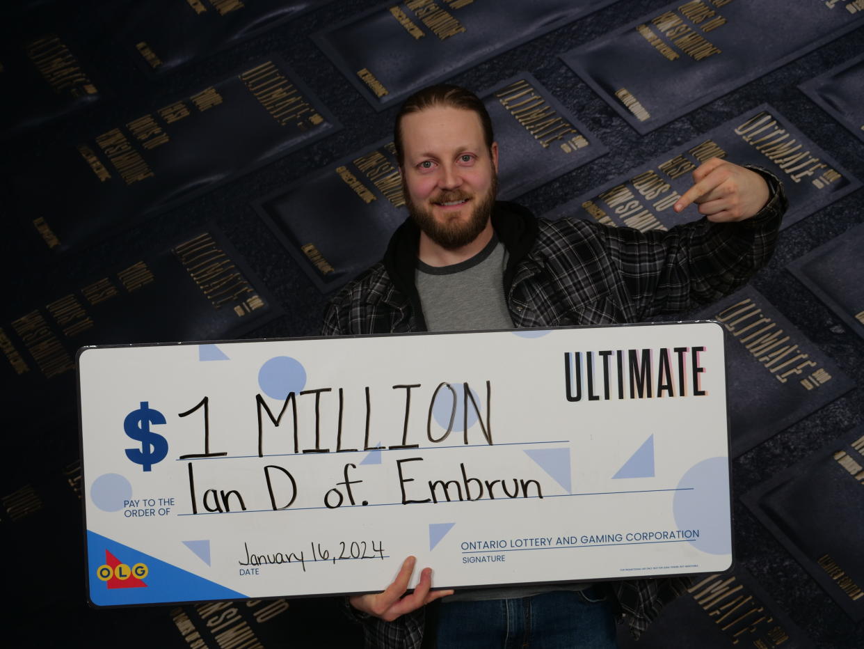 Man holds a $1 million lotto cheque.