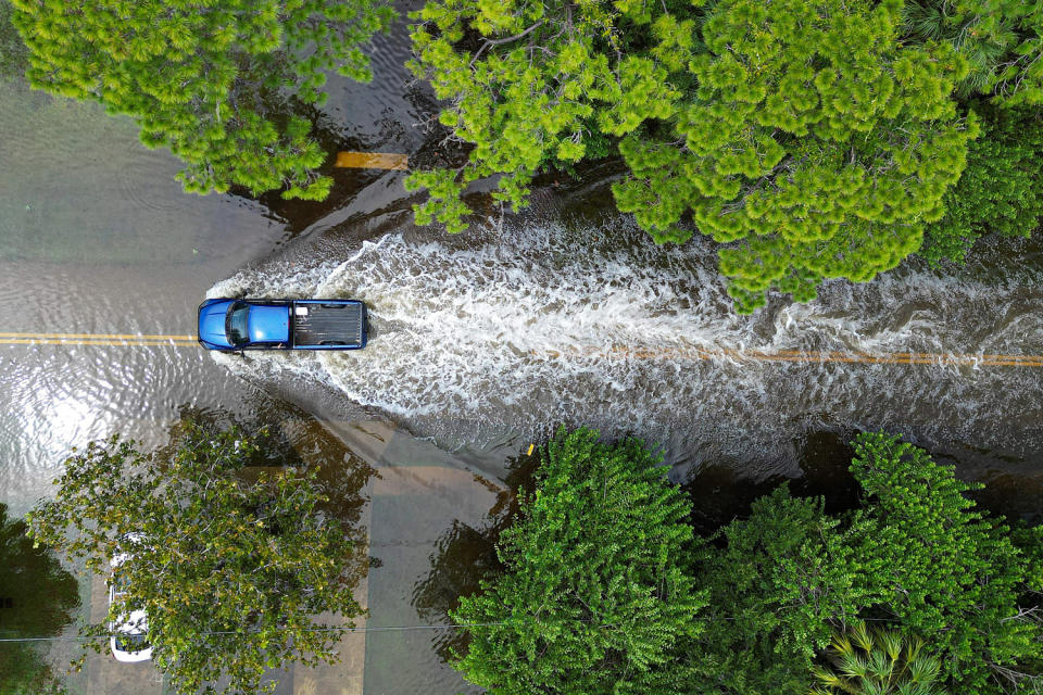 An aerial view of a vehicle driving along a flooded street. (Miguel J. Rodriguez Carrillo  / AFP via Getty Images)