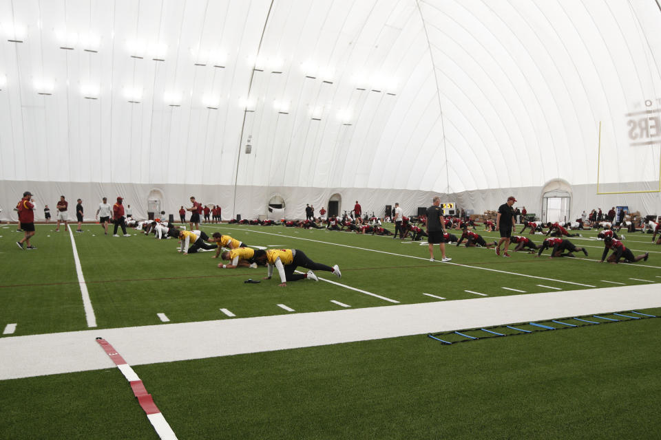 Washington Commanders players stretch out during NFL football practice at the team's indoor training facility in Ashburn, Va., Thursday, June 8, 2023. (AP Photo/Luis M. Alvarez)