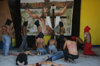 Hooded Filipino penitents perform rituals including flagellating one another in front of an image of Jesus Christ during Maundy Thursday, April 17, 2014, in suburban Mandaluyong, east of Manila, Philippines. The ritual is frowned upon by church leaders in this predominantly Roman Catholic country. (AP Photo/Aaron Favila)