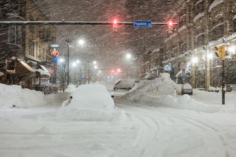 Vehicles are seen abandoned in heavy snowfall in downtown Buffalo, New York, on December 26, 2022.