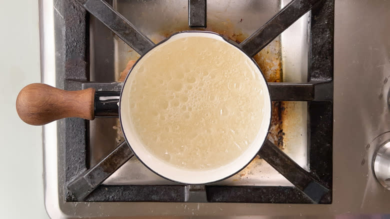 Sugar and water boiling in saucepan on stovetop