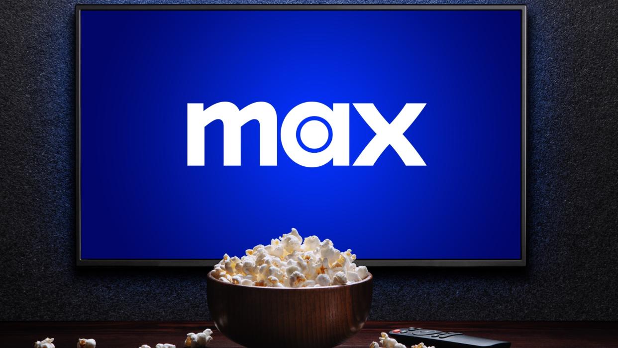  Max logo on TV with popcorn and remote control on table . 