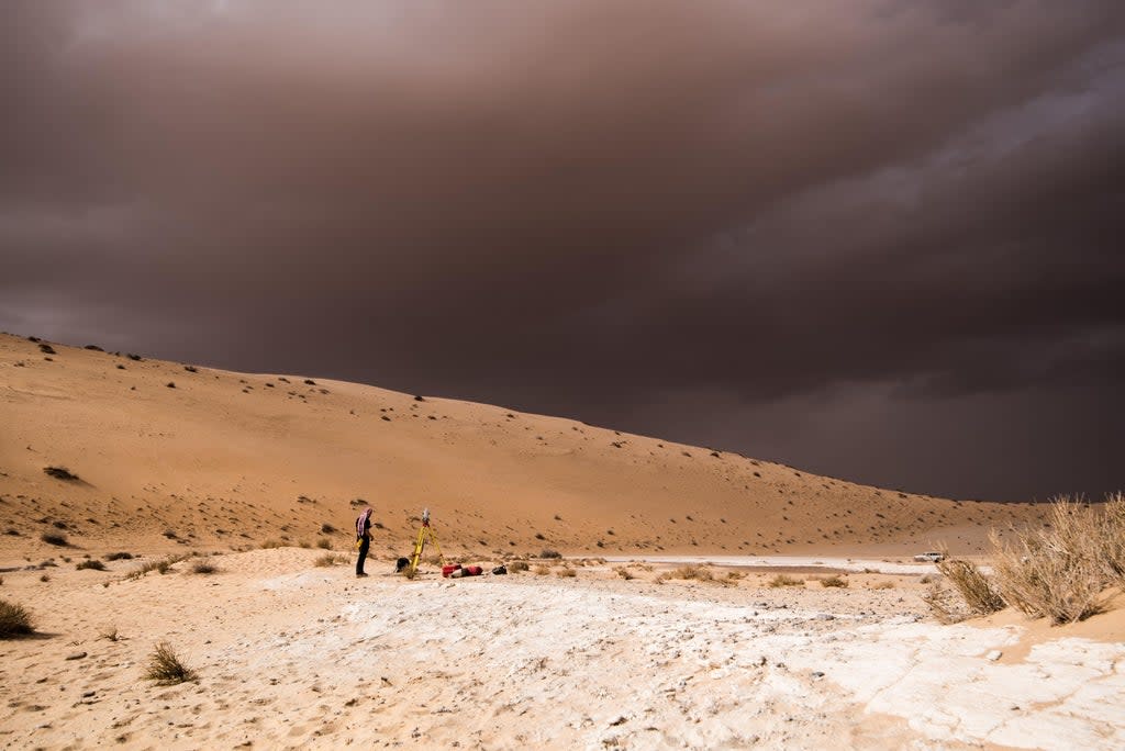 File: A storm arrives during an archaeological excavation of the remains of an ancient lake in northern Saudi Arabia, where ancient humans lived alongside animals like hippos (Palaeodeserts Project (photo by Klint Janulis))