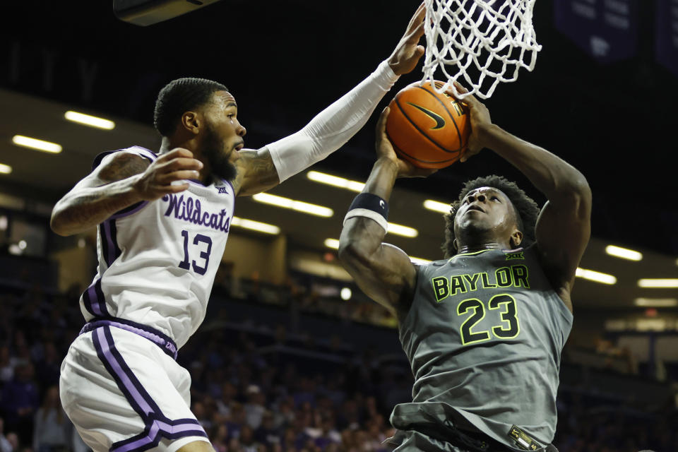 Kansas State guard Desi Sills (13) attempts to block Baylor forward Jonathan Tchamwa Tchatchoua (23) during the first half of an NCAA college basketball game, Tuesday, Feb. 21, 2023, in Manhattan, Kan. (AP Photo/Colin E. Braley)