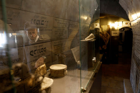 Ahron Seiden, curator of "The Chamber of the Holocaust", a little-known memorial site for Jewish victims of the Nazi Holocaust, is reflected in a display cabinet at the memorial site in Jerusalem's Mount Zion January 23, 2019. REUTERS/Ronen Zvulun