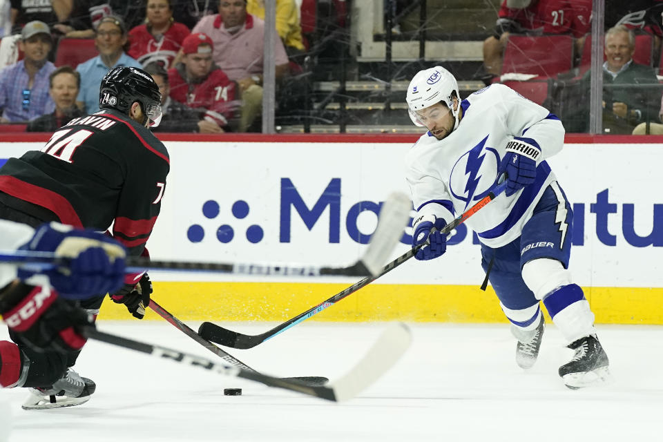 Tampa Bay Lightning center Tyler Johnson (9) shoots while Carolina Hurricanes defenseman Jaccob Slavin (74) defends during the first period in Game 5 of an NHL hockey Stanley Cup second-round playoff series in Raleigh, N.C., Tuesday, June 8, 2021. (AP Photo/Gerry Broome)