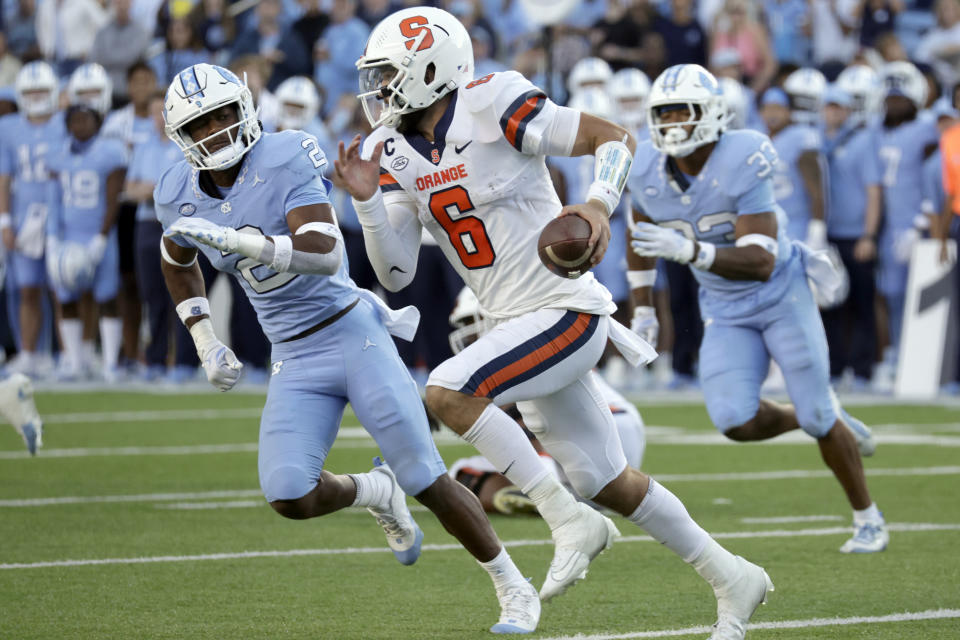 Syracuse quarterback Garrett Shrader (6) runs the ball against North Carolina defensive back Don Chapman (2) and North Carolina linebacker Cedric Gray (33) during the second half of an NCAA college football game, Saturday, Oct. 7, 2023, in Chapel Hill, N.C. (AP Photo/Chris Seward)