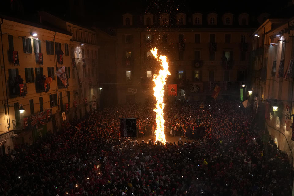 People attend the 'Battle of the Oranges" where people pelt each other with oranges as part of Carnival celebrations in the northern Italian Piedmont town of Ivrea, Italy, Tuesday, Feb. 13, 2024. (AP Photo/Antonio Calanni)