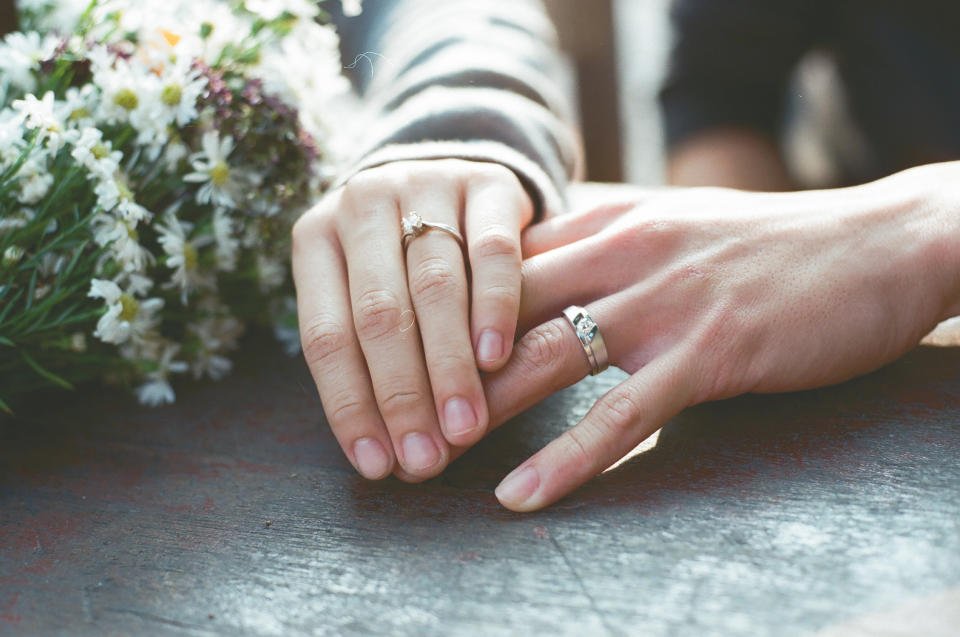 Couple wearing wedding rings. 