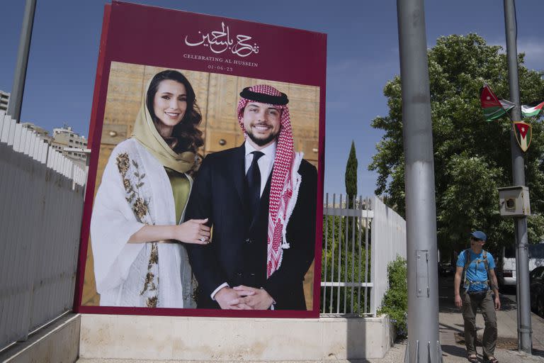 Un cartel con fotos del príncipe heredero Hussein y su prometida, la arquitecta saudita Rajwa Alseif, en la calle principal del centro de Amán, Jordania, el martes 30 de mayo de 2023. 