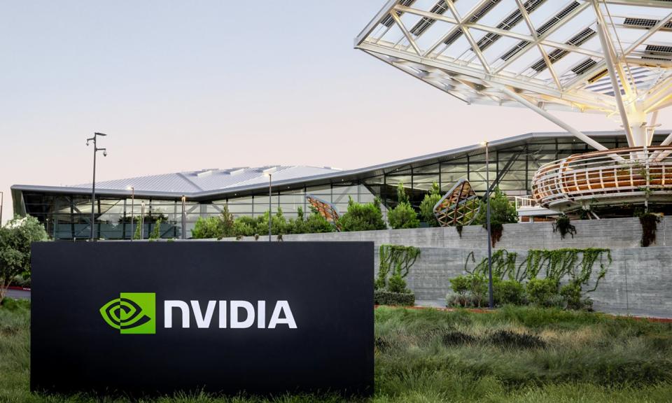 An Nvidia sign outside of a large glass building.