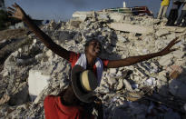 <p>Maxi Phalone sings praises to God after her sister was pulled alive from the rubble of a collapsed building in Port-au-Prince, Monday, Jan. 18, 2010. (Photo: Julie Jacobson/AP) </p>