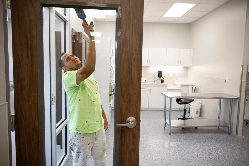 Cesar Puerto, of Charlotte, N.C., works to paint door trim in the new medical facility at the new Humane Society of Charlotte in Charlotte, N.C., Thursday, May 12, 2022. The new 27,000 square foot facility located on Parker Drive will provide spaces such as a cafe and a new medical facility when it opens later this month.