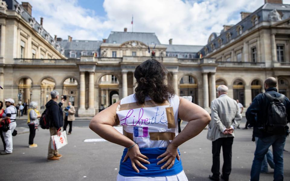 Protesters railing against Covid passports gathered outside the French Constitutional Council earlier, such as this one displaying 'liberty' on her jacket -  IAN LANGSDON/EPA-EFE/Shutterstock