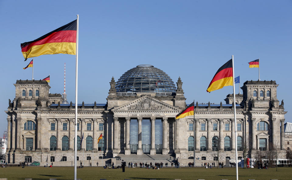 FILE - German flags wave in front of the Reichstag building, host of the German Federal Parliament Bundestag, in Berlin, Germany, Tuesday, March 5, 2013. German lawmakers have approved legislation easing rules to gain citizenship and ending restrictions on holding dual citizenship. (AP Photo/Michael Sohn, File)