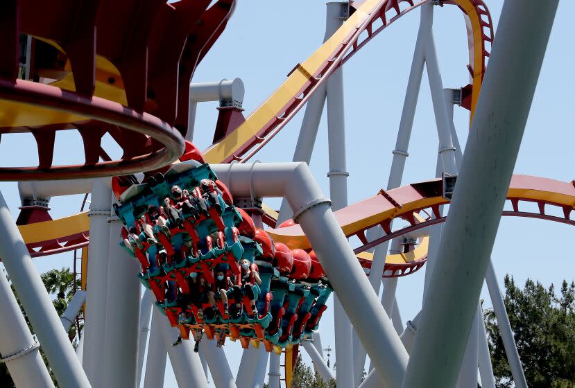 BUENA PARK, CA - MAY 06:. Visitors enjoy a thrill ride as Knott's Berry Farm reopened to season passholders on Thursday, May 6, 2021. The famed amusement park has been closed for more than a year because of the coronavirus pandemic lockdown, but plans to reopen to the general public on May 21. The number of visitors will be limited and parkgoers must follow safety protocols, including wearing masks and social distancing. (Luis Sinco / Los Angeles Times)