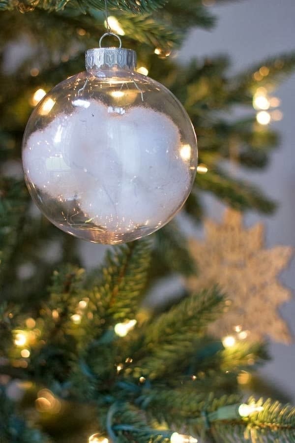 Ball ornament with "snow" inside hanging from a tree
