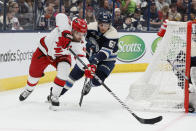 Carolina Hurricanes' Jordan Martinook, left, controls the puck as Columbus Blue Jackets' Luca Del Bel Belluz defends during the first period of an NHL hockey game Tuesday, April 16, 2024, in Columbus, Ohio. (AP Photo/Jay LaPrete)