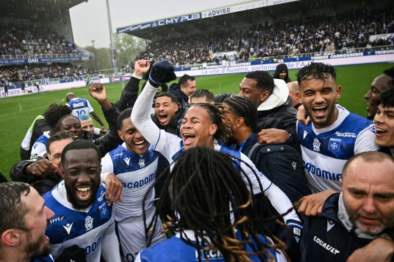 La joie des joueurs d'Auxerre après leur succès face au Paris FC, synonyme de remontée quasi assurée en Ligue 1, le 4 mai 2024 au stade l'Abbé-Deschamps (ARNAUD FINISTRE)