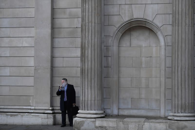 FILE PHOTO: A man smokes outside the Bank of England in the City of London