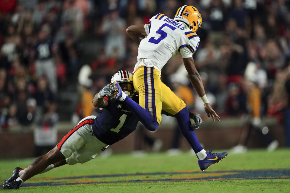 LSU quarterback Jayden Daniels (5) breaks away from Auburn safety Donovan Kaufman (1) in the first half of an NCAA college football game, Saturday, Oct. 1, 2022, in Auburn, Ala. (AP Photo/John Bazemore)