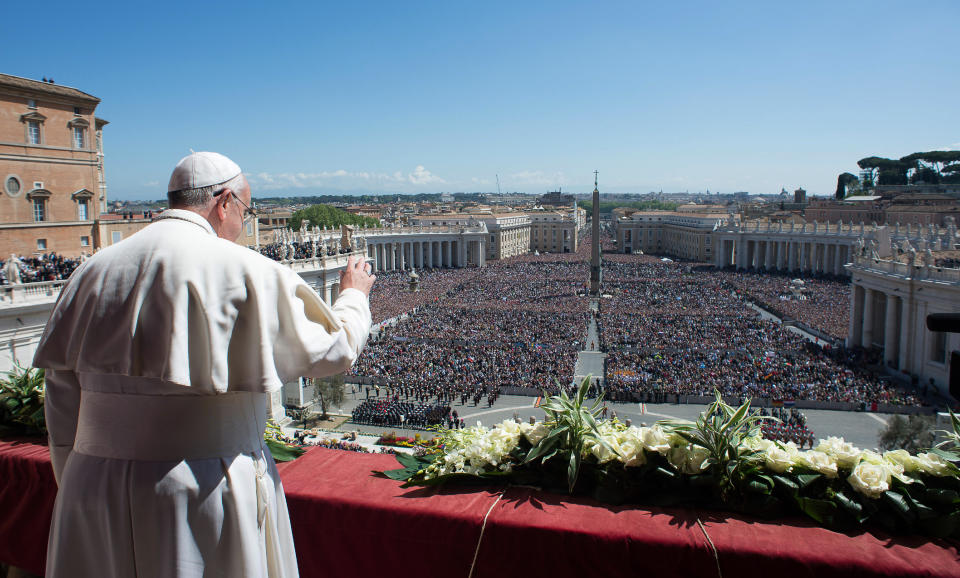 In this photo provided by the Vatican newspaper L'Osservatore Romano, Pope Francis waves to the crowd from the balcony of St. Peter's Basilica where he delivered the Urbi et Orbi (Latin for to the city and to the world) at the end of the Easter Mass in St. Peter's Square at the the Vatican Sunday, April 20, 2014. (AP Photo/L'Osservatore Romano, ho)