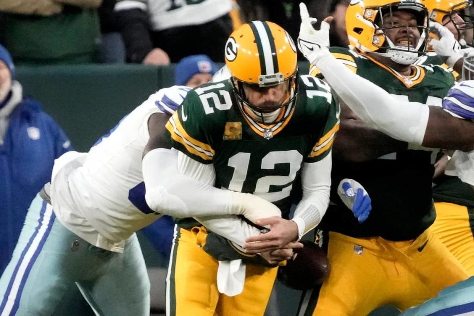 Green Bay Packers quarterback Aaron Rodgers (12) fumbles the ball after being sacked by Dallas Cowboys defensive end DeMarcus Lawrence, left, during the first half of their game Sunday at Lambeau Field.