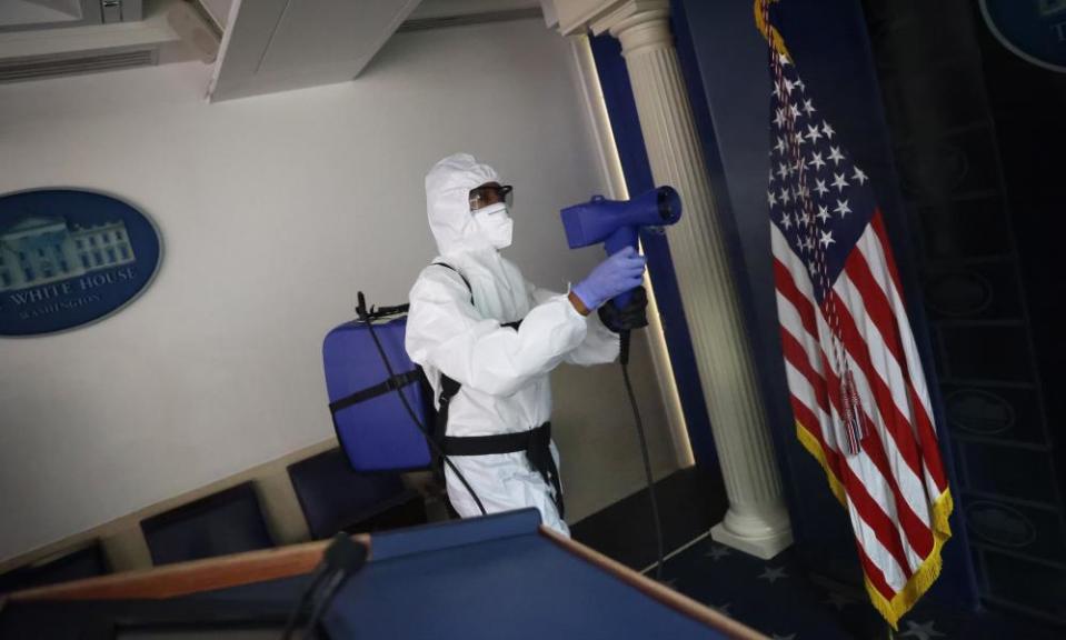 A member of the White House cleaning staff sanitises the press area of the building on Monday