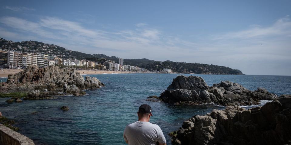 A tourist overlooks the bay in Lloret De Mar, Catalonia, Spain, in April 2022